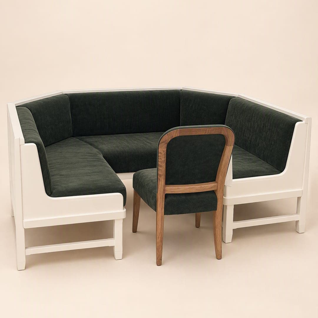 A corner booth sofa with a dark green upholstered seat and back and a timber chair